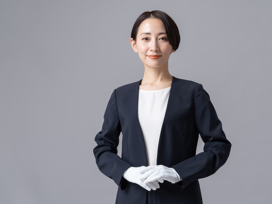 身体の前で手を揃える姿勢の正しい女性スタッフを表す画像