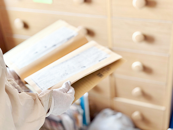 古いノートを開き、内容を確認する様子を表す画像