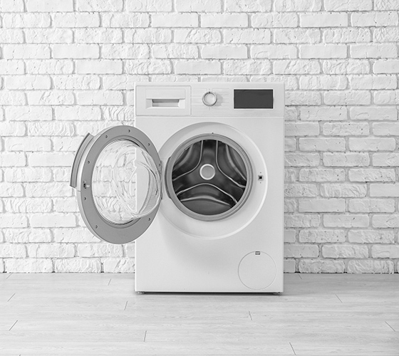 白い部屋の中におかれた白いドラム式洗濯機の画像